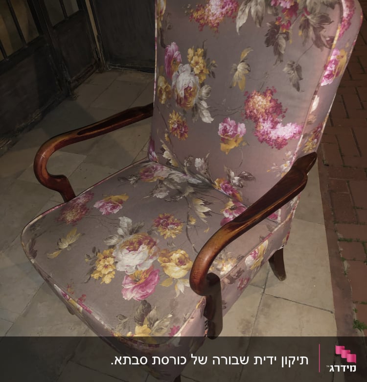 כורסה מרופדת בבד פרחוני צבעוני עם ידיות עץ